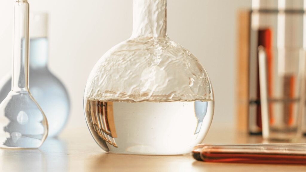 Glass laboratory flask in soft natural light, symbolizing the clinical, personalized approach to peptide therapy at Good Chemistry in Cumming, GA.