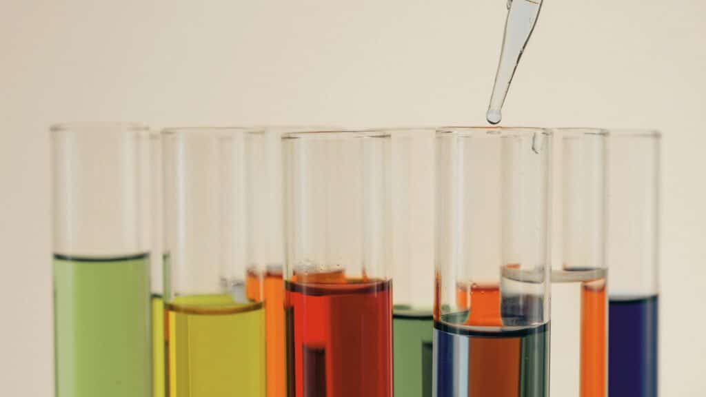 Colorful test tubes and a glass dropper representing pharmaceutical-grade peptide therapy in Cumming, GA at Good Chemistry Health & Med Spa.