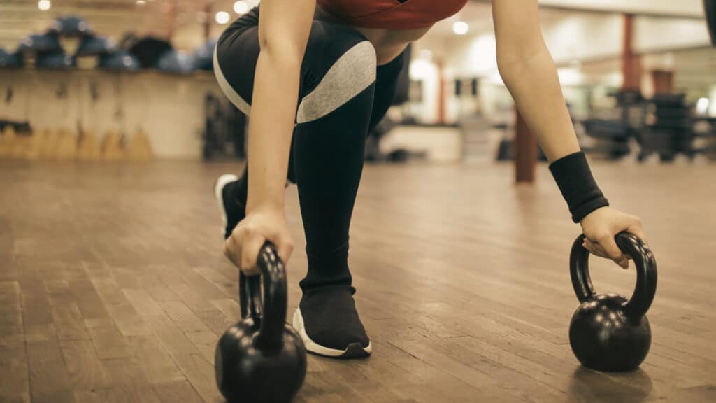 Woman performing kettlebell training to preserve muscle mass during medical weight loss in Cumming, GA at Good Chemistry