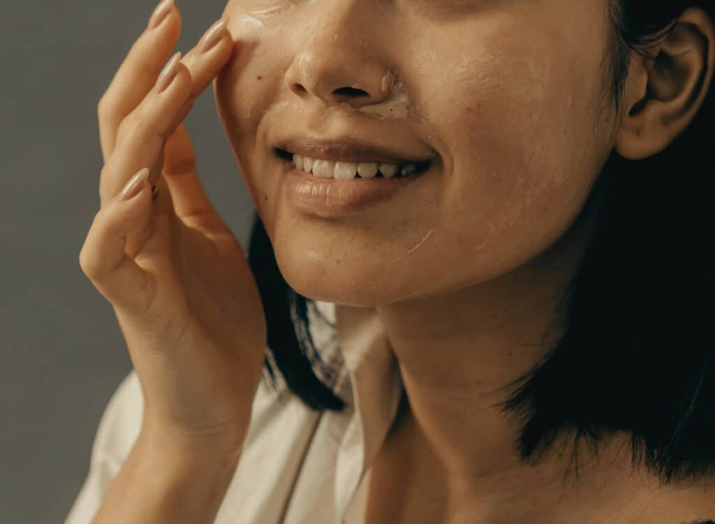 Moisturizing serum being applied to glowing skin after microneedling facial treatment in Cumming GA