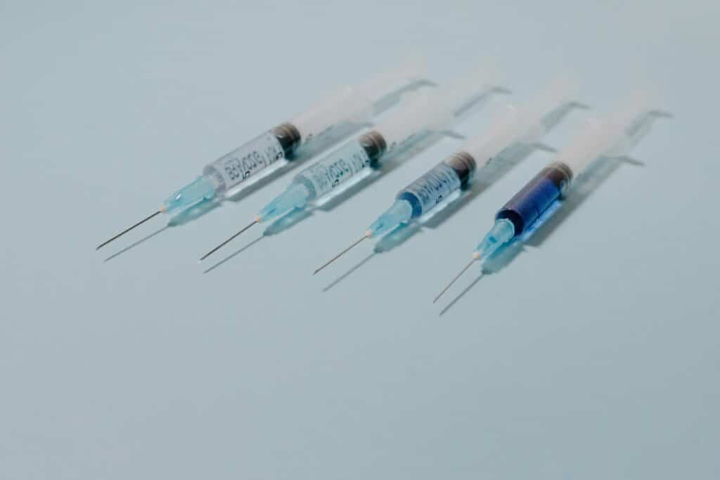 A row of peptide syringes graduating from clear to deep blue, illustrating the gradual, consistent results patients experience with peptide therapy at Good Chemistry in Cumming, GA.