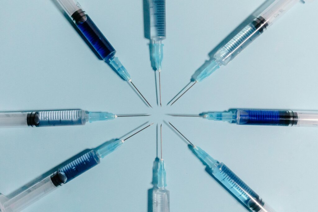 Circular arrangement of eight syringes symbolizing the variety of peptides — including BPC-157, CJC-1295, Ipamorelin, and MOTS-c — used in peptide therapy for energy and longevity.
